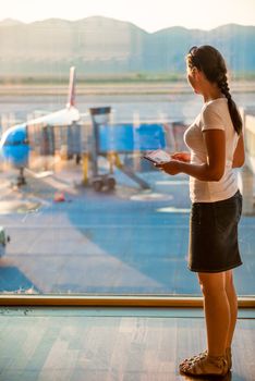 girl looks through the glass on the plane