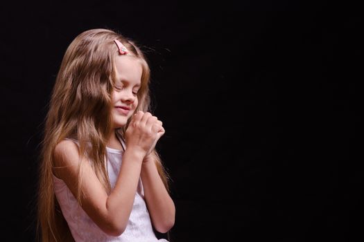 Portrait of a beautiful five year old girl on a black background