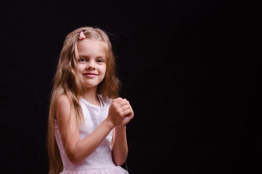 Portrait of a beautiful five year old girl on a black background