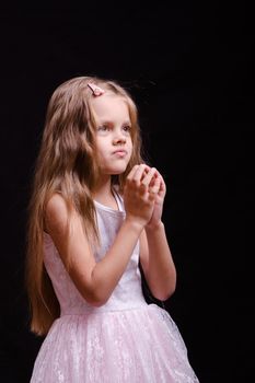 Portrait of a beautiful five year old girl on a black background