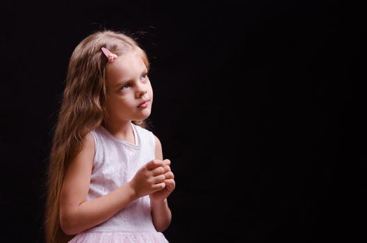 Portrait of a beautiful five year old girl on a black background