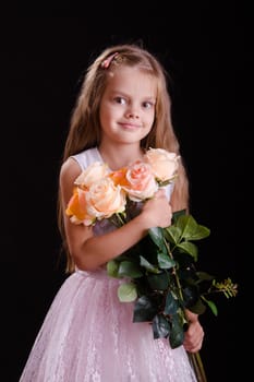 Portrait of a five year old girl with a bouquet of flowers on a black background