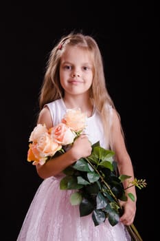 Portrait of a five year old girl with a bouquet of flowers on a black background