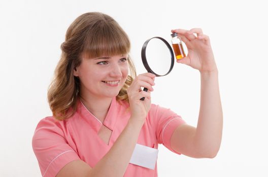 Pharmacist sitting at the table reading a thick handbook of medicines
