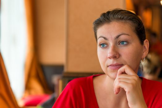 beautiful brunette 30 years lost in thought in the cafe