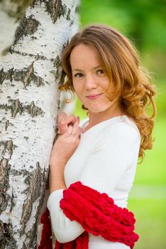 young beautiful girl with red hair in a birch