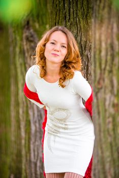 red-haired girl in white dress among the trees