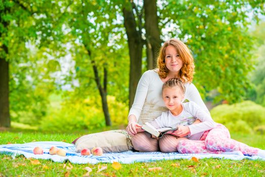 Beautiful mother and daughter spend a weekend at a picnic in the park