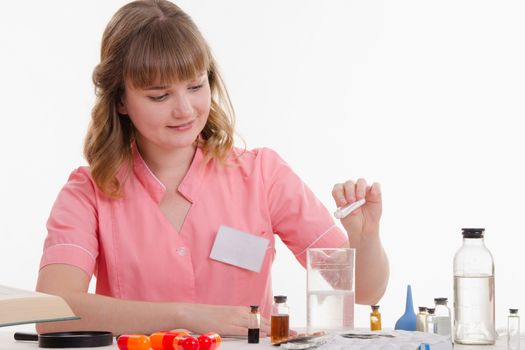 Pharmacist sitting at the table reading a thick handbook of medicines