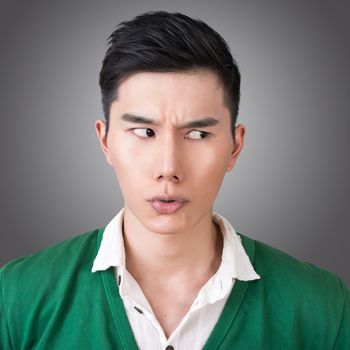 Funny facial expression, closeup Asian young man.