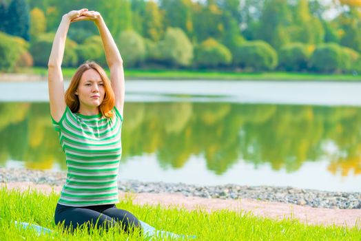 girl performs stretching exercises back muscles in nature