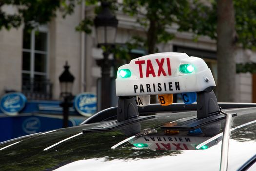 The Taxi sign on top of the roof of the cab in Paris