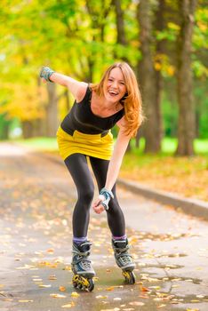 beautiful cheerful girl roller skate active in the autumn park