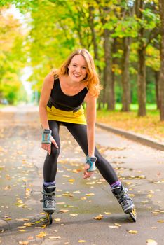 athlete posing on skates in the autumn deserted park