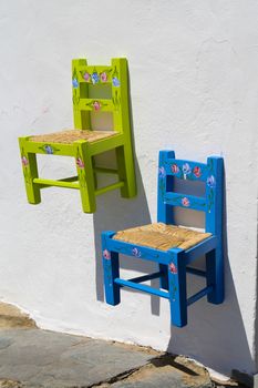 Two child chairs hanging on the wall