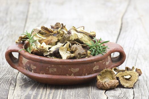 dried mushrooms in a bowl on wooden background