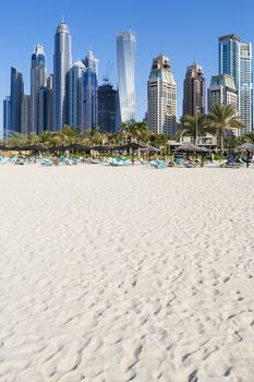 DUBAI, UAE - November 28: Tourists on city beach, November 28, 2014 in Dubai. More than 10 million people visit the city every year. 