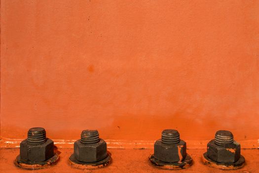 Orange painted background with four big bolts