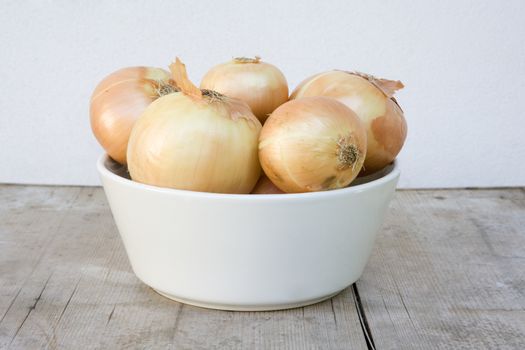 white bowl with brown onions on wooden board