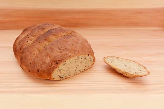 Fresh multi seed malted bread loaf with the crust cut off on a wooden surface
