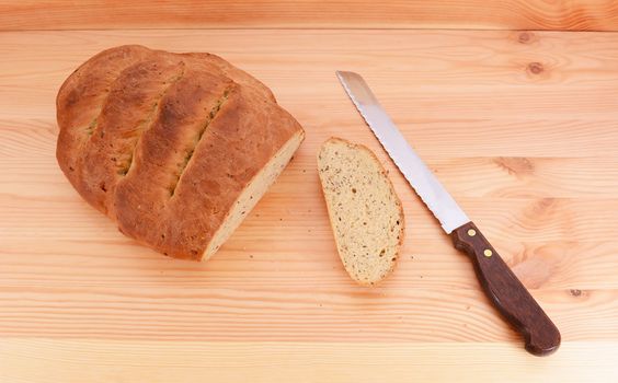 Bread knife with a freshly baked seeded loaf, first crust sliced off