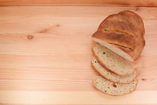 Fresh bread and cut slices border copy space on a wooden table