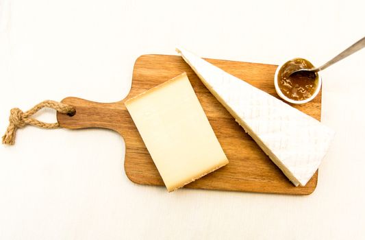 Appetizer cheese on a wooden plate isolated on white background