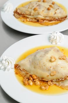 pancake crepe with peanuts and honey decorated with whipped cream