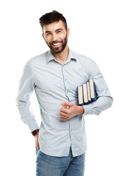 Young bearded smiling man with books in hand on white background