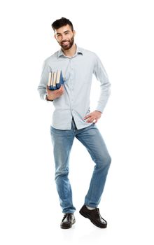 Young bearded smiling man with books in hand on white background