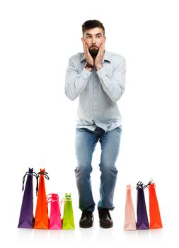 Handsome man with shopping bags is shocked. Christmas and holidays concept