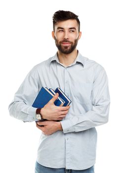 Young bearded smiling man with books in hand on white background