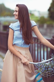 Young beautiful, elegantly dressed woman with bicycle. Beauty, fashion and lifestyle