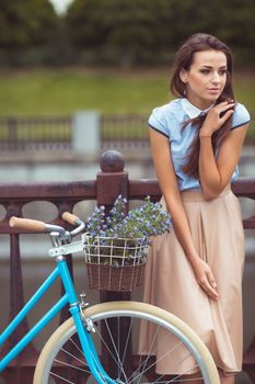 Young beautiful, elegantly dressed woman with bicycle. Beauty, fashion and lifestyle