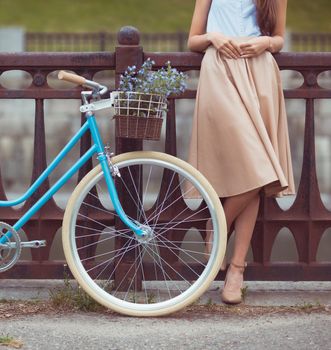 Young beautiful, elegantly dressed woman with bicycle. Beauty, fashion and lifestyle