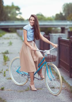 Young beautiful, elegantly dressed woman with bicycle. Beauty, fashion and lifestyle