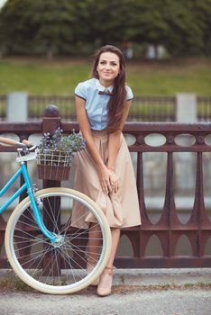 Young beautiful, elegantly dressed woman with bicycle. Beauty, fashion and lifestyle