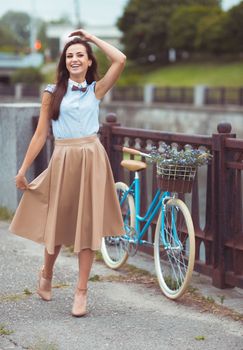 Young beautiful, elegantly dressed woman with bicycle. Beauty, fashion and lifestyle