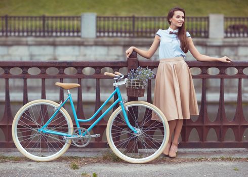 Young beautiful, elegantly dressed woman with bicycle. Beauty, fashion and lifestyle