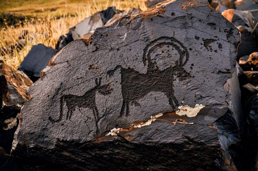 Ancient pictogram of animals on rock on Saimaluu Tash site in Kyrgyzstan