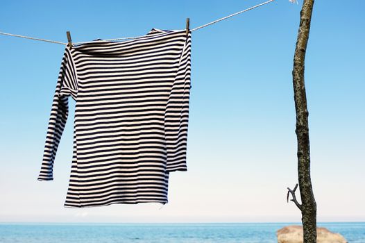 Striped shirt hanging on a rope on the seashore