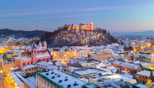 Aerial panoramic view of Ljubljana decorated for Christmas holidays. Roofs covered in snow in winter time. Slovenia, Europe.