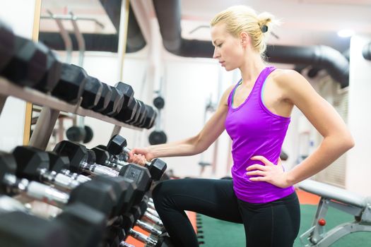 Beautiful blonde woman working out in a gym studio.