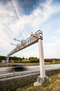 truck passing through a toll gate on a highway (motion blurred image; color toned image)