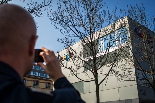ZURICH, SWITZERLAND - MARCH  14, 2014: Man taking a photo wiht his smartphone of the Google Corporation Building