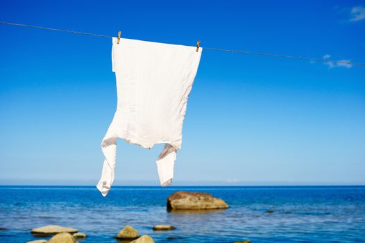 White shirt hanging on a rope on the seashore