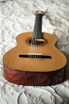 Spanish guitar lying on the bed