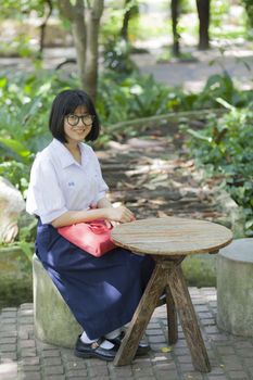 student sitting on the bench. In the park A wooden table in front And an area for relaxation