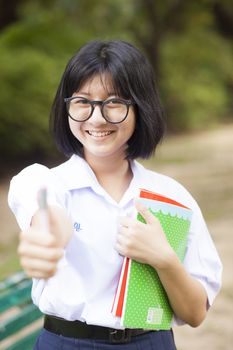Schoolgirl. Smiling and holding a book Smiling and happy and relaxed. Within the park