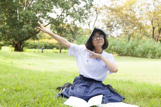 Girl is happy and relaxed. Sitting on the grass in the garden. While being homework